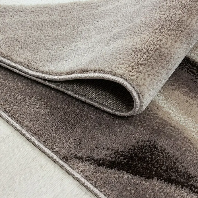 Kurzflorteppich Parma 9310 - Braun, 170 x 120 cm, 100% Polypropylen - Detailaufnahme eines modernen Teppichs mit abstraktem Muster in Grau- und Beigetönen, der eine stilvolle Atmosphäre schafft.