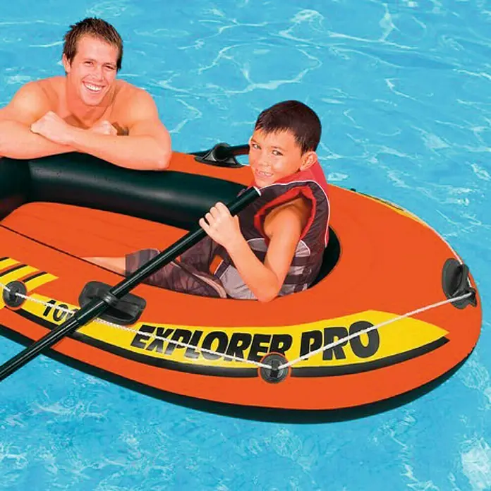 Intex Bote hinchable Explorer Pro 100 - L x An x Al: 160 x 94 x 29 cm, Apto para: 1 persona, Carga útil: 80 kg - Un bote inflable naranja Explorer Pro con un adulto y un niño en el agua.