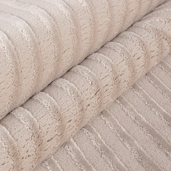 Kurzflorteppich Sahara IV - Beige, 290 x 200 cm, 100 % Polypropylen - Nahaufnahme eines gewickelten Cordstoffes in einem neutralen Farbton, der eine weiche, strukturierte Oberfläche und subtile Schatten zeigt.