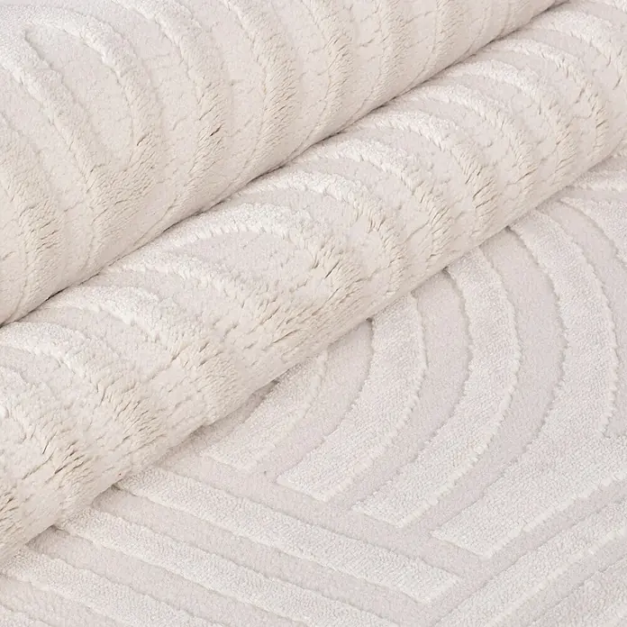 Kurzflorteppich Sahara I - Creme, 250 x 80 cm, 100 % Polypropylen - Nahaufnahme eines gerollten, weißen Teppichs mit strukturiertem Muster für ein gemütliches Ambiente in Ihrem Zuhause.