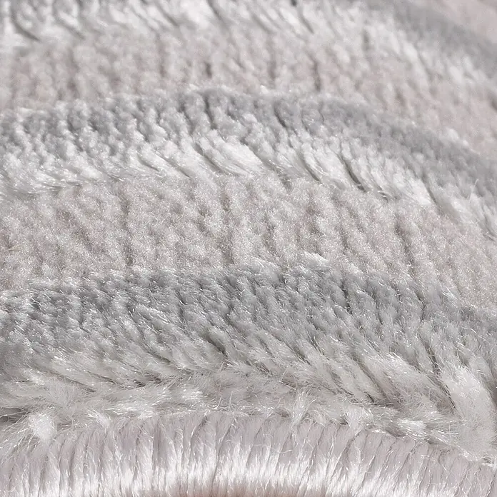 Kurzflorteppich Sahara III - Silber, 170 x 120 cm, 100 % Polypropylen - Nahaufnahme eines weichen, hellgrauen Teppichs, der Wärme und Komfort ausstrahlt. Die Textur lädt zum Berühren ein und verspricht Behaglichkeit.