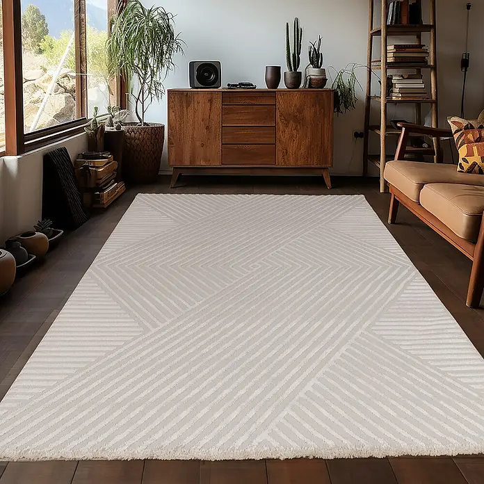 Kurzflorteppich Sahara IV - Beige, 290 x 200 cm, 100 % Polypropylen - Ein stilvoller, cremefarbener Teppich mit modernem, geometrischem Design liegt in einem hellen Wohnzimmer.