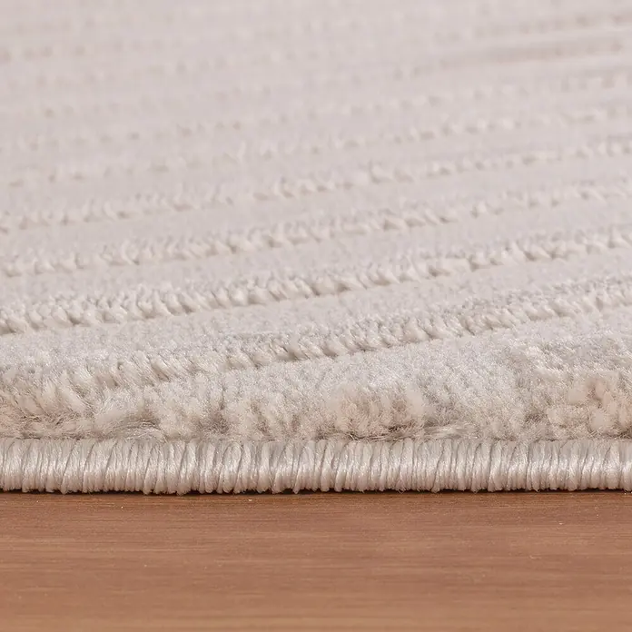 Kurzflorteppich Sahara IV - Beige, 290 x 200 cm, 100 % Polypropylen - Detailaufnahme eines cremefarbenen Teppichs mit subtilem Muster und sauberer Kante, ideal für Wohnräume.