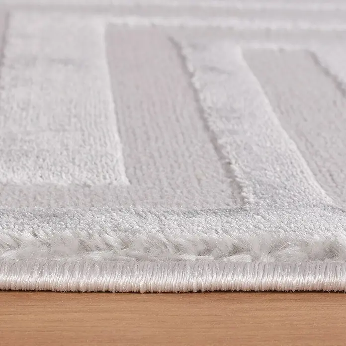 Kurzflorteppich Sahara V - Silber, 340 x 240 cm, 100 % Polypropylen - Nahaufnahme eines weichen, weißen Teppichs mit einem geometrischen Muster, ideal für Badezimmer oder Schlafzimmer, der Komfort und Stil bietet.