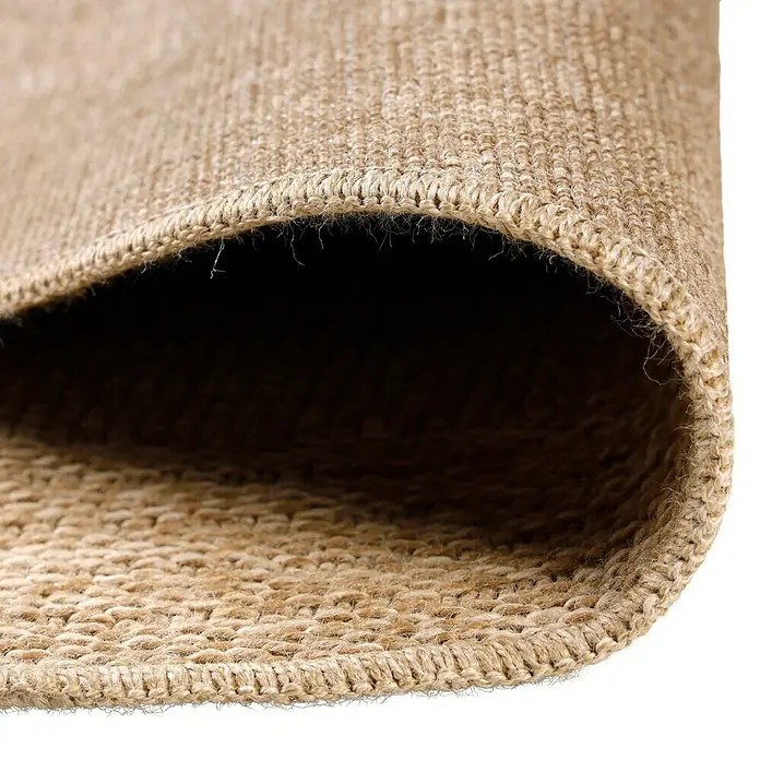 Outdoor-Teppich Comilla I - Beige, Durchmesser: 80 cm, 100 % Polypropylen - Detailaufnahme eines gewebten Teppichs mit brauner Farbe und sichtbarer Textur. Der Teppich ist aufgerollt, was seine dicke und robuste Konstruktion zeigt.