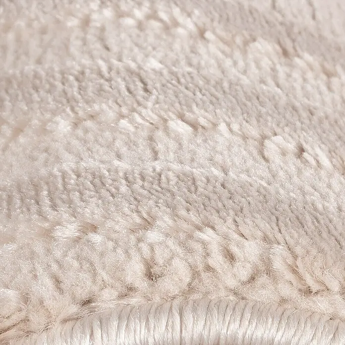 Kurzflorteppich Sahara II - Beige, 170 x 120 cm, 100 % Polypropylen - Nahaufnahme eines cremefarbenen Teppichs mit weicher, zotteliger Textur, der Wärme und Komfort in den Raum bringt.