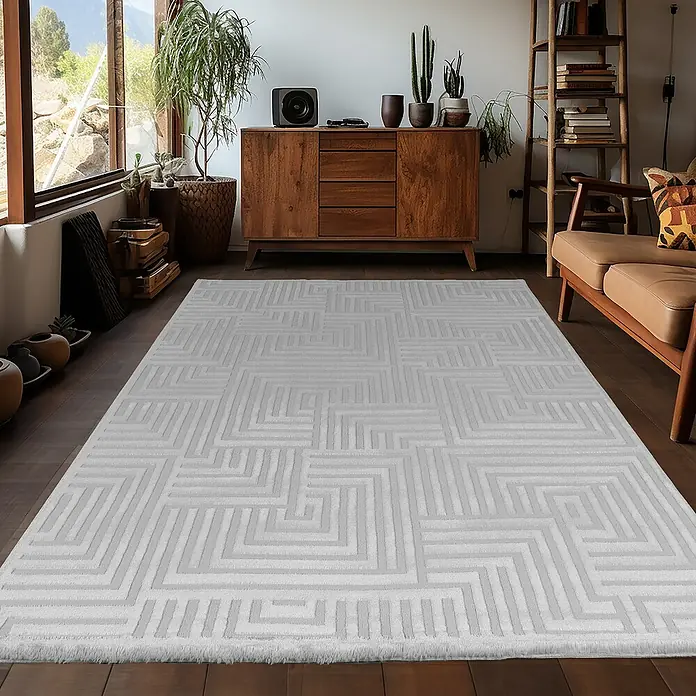Kurzflorteppich Sahara III - Silber, 170 x 120 cm, 100 % Polypropylen - Nahaufnahme eines modernen, hellgrauen Teppichs mit geometrischem Muster in einem stilvollen Wohnzimmer.