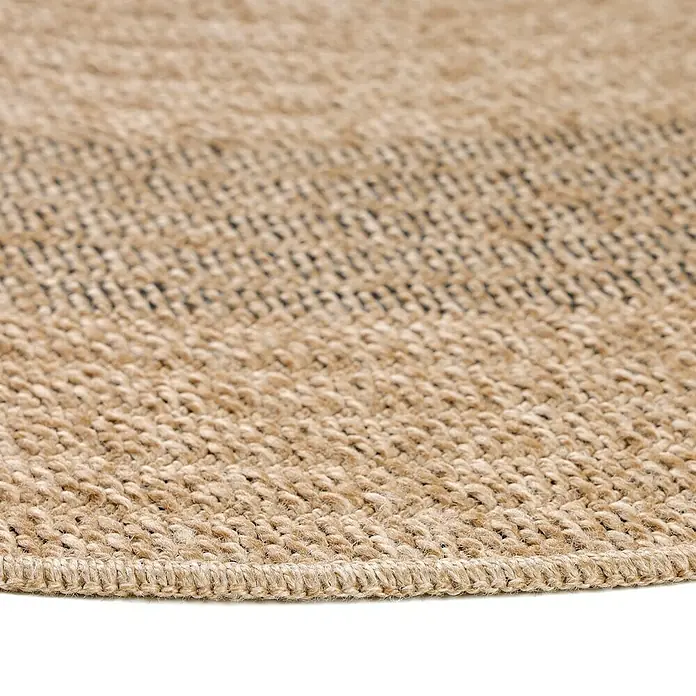 Outdoor-Teppich Comilla I - Schwarz, Durchmesser: 80 cm, 100 % Polypropylen - Detailansicht eines runden Juteteppichs mit geflochtener Bordüre. Der Teppich zeigt eine natürliche Farbgebung und eine robuste Textur.