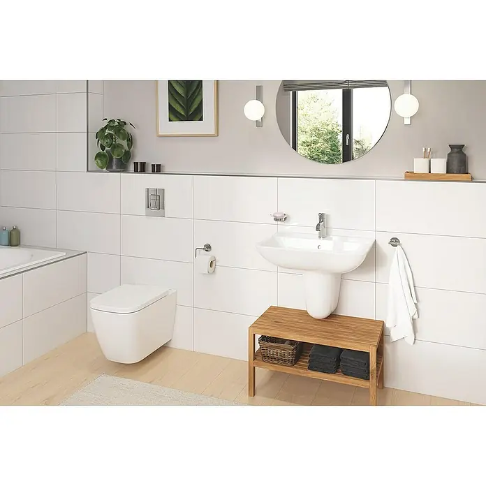 Grohe Betätigungsplatte Even - Chrom, Spül-Stopp-Spülung - Badezimmer-Interieur mit weißem Wand-WC und Waschtisch mit Holzablage, ergänzt durch einen runden Spiegel und dezente Dekorationselemente.