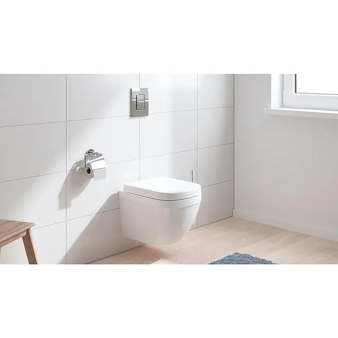 Grohe Betätigungsplatte Even - Chrom, Spül-Stopp-Spülung - Modernes Badezimmer mit einer wandhängenden Toilette, weißen Fliesen und einem hellen Holzfußboden. Die Toilette ist ein elegantes, platzsparendes Designelement.