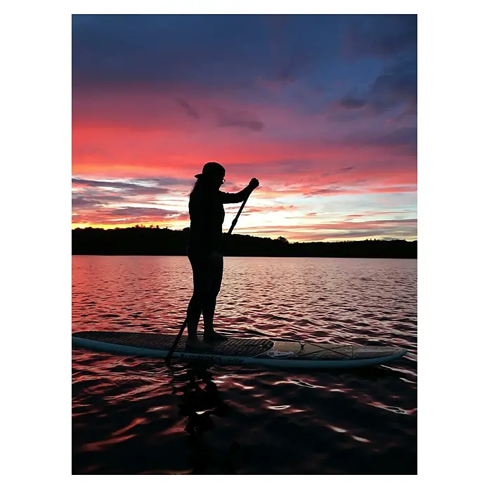 Paddle surf Race XQMax - L x An x Al: 381 x 66 x 15 cm, Carga útil: 150 kg, Hinchable - Silueta de una persona en una tabla de paddle surf al atardecer. La tabla parece ser un modelo AM.