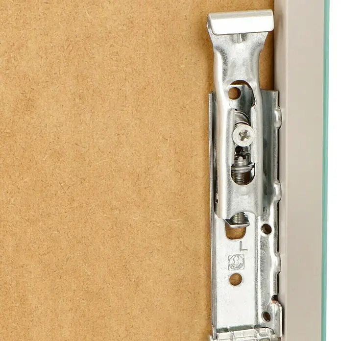 Riva Look LED-Spiegelschrank - B x H: 60,6 x 64,8 cm, Mit Beleuchtung - Detailansicht eines Möbelscharniers aus Metall, befestigt an einer Holzplatte und einem Rahmen. Ein Schraubenkopf ist deutlich sichtbar.