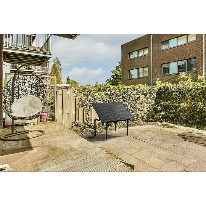 Technaxx Solar-Tischkraftwerk 400 W TX-250 - 400 W, L x B x H: 173 x 114 x 84 cm - Eine Solaranlage steht auf einer Terrasse, umgeben von einem Stuhl und einem Grill. Die Anlage ist elegant und effizient.