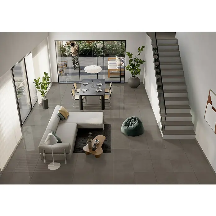 Art-Tec by Palazzo Feinsteinzeugfliese - 59,5 x 59,5 cm, Taupe, Glänzend - Ein helles Wohnzimmer mit grauen Fliesen, einer Couch, einem Esstisch und einer Treppe, die zu einem minimalistischen und modernen Ambiente beiträgt.