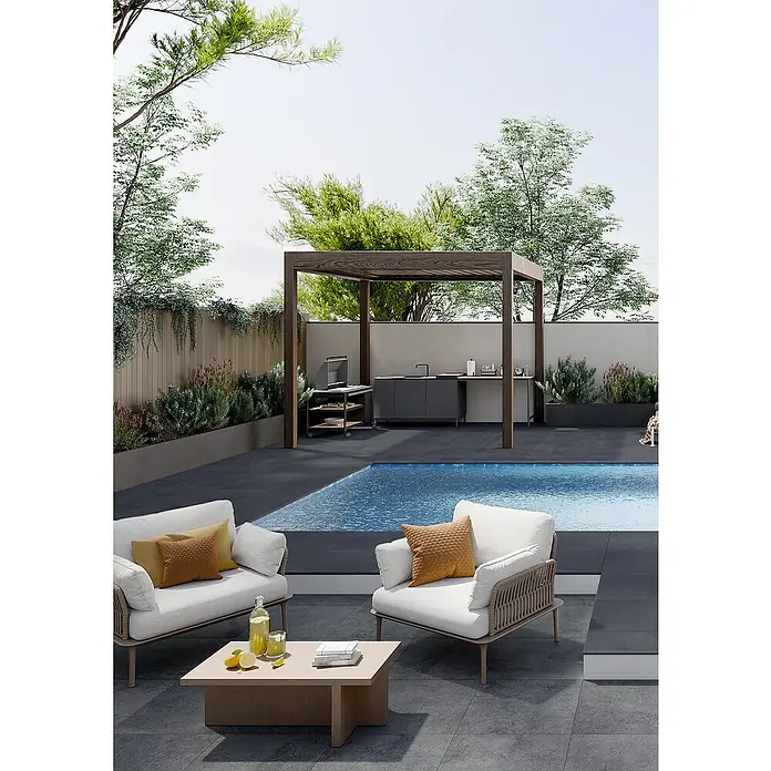 Art-Tec by Palazzo Terrassenfliese - 60 x 60 x 2 cm, Onyx, Matt - Ein moderner Außenbereich mit Pool, Lounge-Sesseln mit Kissen und einem Tisch mit Getränken. Im Hintergrund befindet sich eine stilvolle Outdoor-Küche.