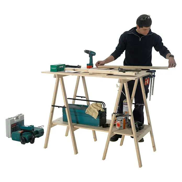 Astigarraga Caballete de madera profesional - Peso máximo admitido: 600 kg, Altura: 100 cm, Pino, Natural - Un artesano está de pie en un banco de trabajo de madera con herramientas y accesorios, trabajando en una tabla de madera.