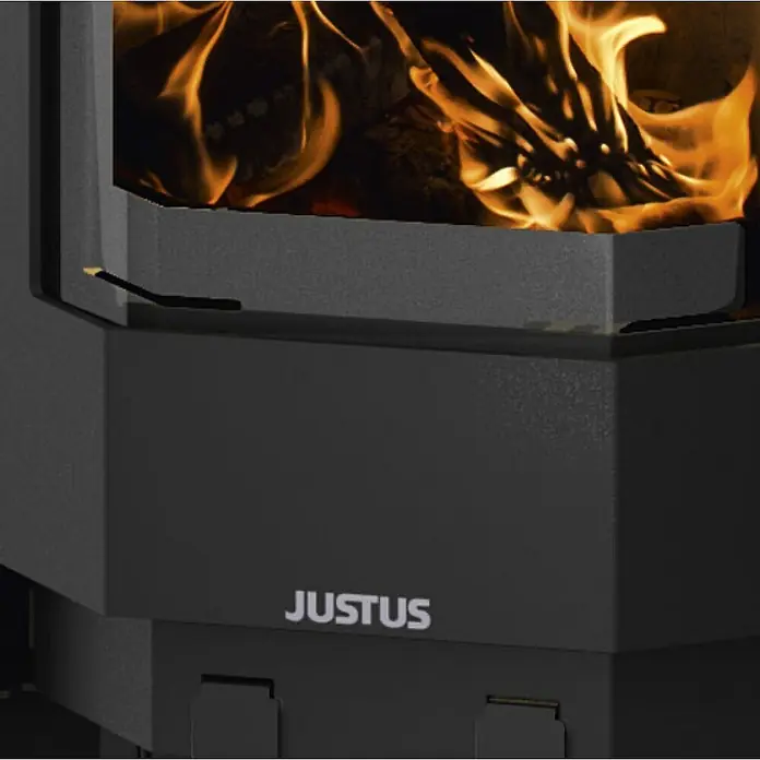 Justus Usedom 5 Kaminofen Usedom W+ 2.0 - 5,5 kW, Raumheizvermögen: 88 m³, Material Verkleidung: Speckstein, Schwarz/Speckstein - Nahaufnahme eines Justus Kaminofens mit brennendem Holz. Das Feuer erzeugt eine warme und gemütliche Atmosphäre.