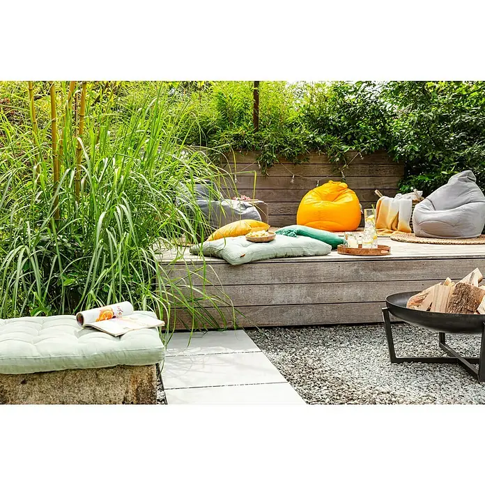 Sitting Point Sitzsack Beanbag Easy - L, Grau, 100 % Polyester - Entspannte Gartenszene mit Sitzsäcken und Kissen auf einer Holzterrasse, ideal zum Verweilen und Entspannen im Freien mit Feuerstelle.