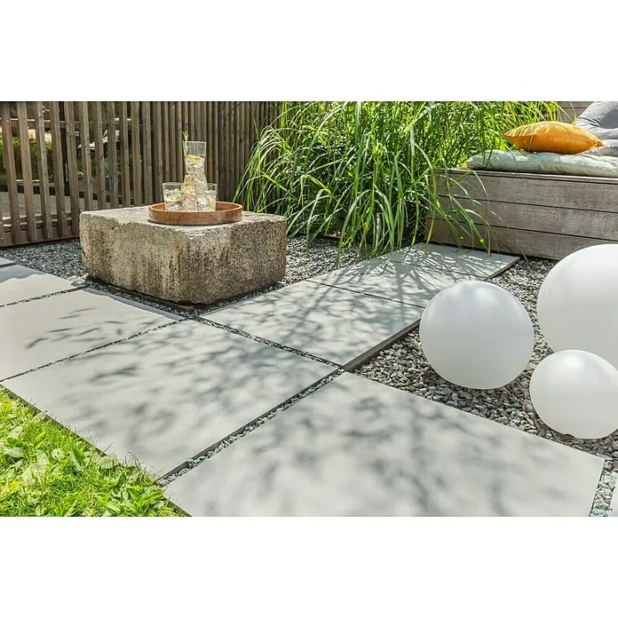 Terrassenfliese Garden Family Lightgrey - 60 x 60 x 2 cm, Hellgrau, Matt - Eine Außenaufnahme von weißen Deko-Kugeln, kombiniert mit modernen Betonplatten und dekorativem Kies für einen stilvollen Gartenbereich.