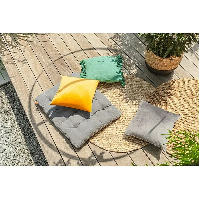 Juteteppich Nature 502 - Naturbraun, Durchmesser: 100 cm, 100 % Jute - Einladende Terrasse mit farbenfrohen Kissen und einem runden Teppich, die eine gemütliche Sitzecke im Freien schaffen.