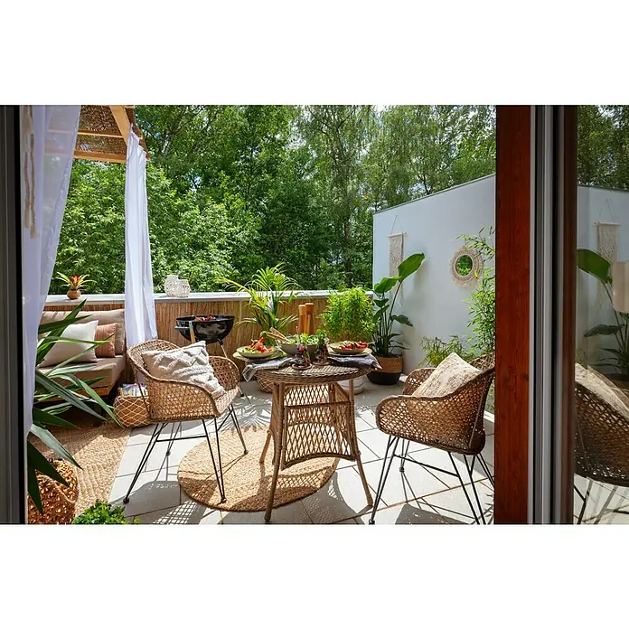 Sunfun Maja GartensesselBraun-Grau, PE-Geflecht - Einladende Terrasse mit Rattanstühlen, Esstisch und Grill. Dekorative Pflanzen und Textilien schaffen eine gemütliche Atmosphäre im Freien.