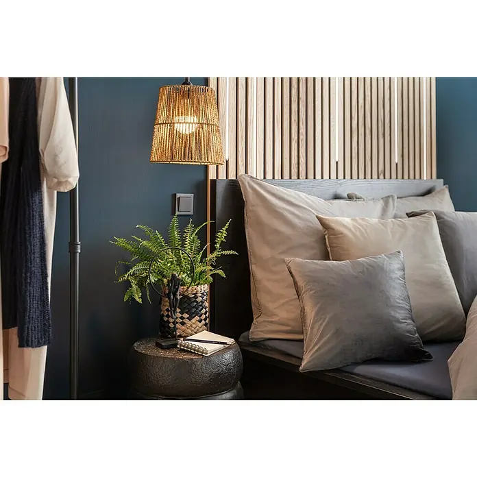 Kissen Finja - Charcoal Grey, 45 x 45 cm, 100 % Polyester - Nahaufnahme eines Schlafzimmers mit einem Nachttisch, einer Lampe, einer Zimmerpflanze und Kissen auf dem Bett.