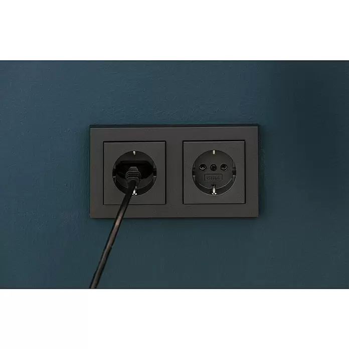 Gira System 55 Steckdose 018828 - Anthrazit, 16 A - Zwei dunkelgraue GIRA Steckdosen an einer dunkelblauen Wand; eine ist mit einem schwarzen Kabel belegt, die andere ist leer.