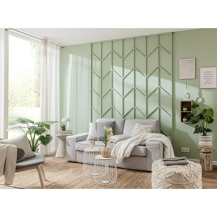 Elbersdrucke Schlaufenbandschal PureB x H: 140 x 255 cm, 100 % Polyester, Weiß - Wohnzimmer mit einem hellgrauen Sofa, Zierkissen und einer weißen Decke. Im Hintergrund befindet sich eine Wand mit einem geometrischen Muster.