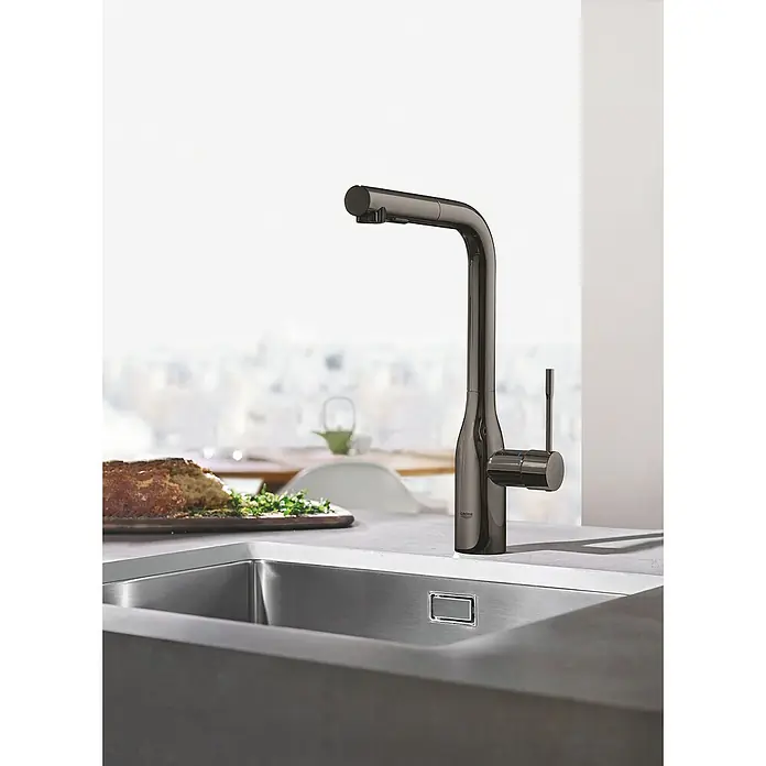 Grohe Essence Spültischarmatur - L-Auslauf, Hard Graphite, Glänzend - Nahaufnahme einer modernen, dunklen Küchenarmatur von Grohe über einer Spüle. Elegantes Design für zeitgemäße Küchen.