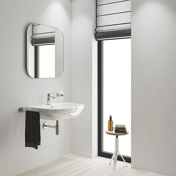 Grohe Eurostyle Cosmopolitan Waschtischarmatur S-Size - Chrom, Glänzend - Modernes Badezimmerwaschbecken mit Armatur, Spiegel und einem kleinen Tisch mit Handtüchern und Seife.