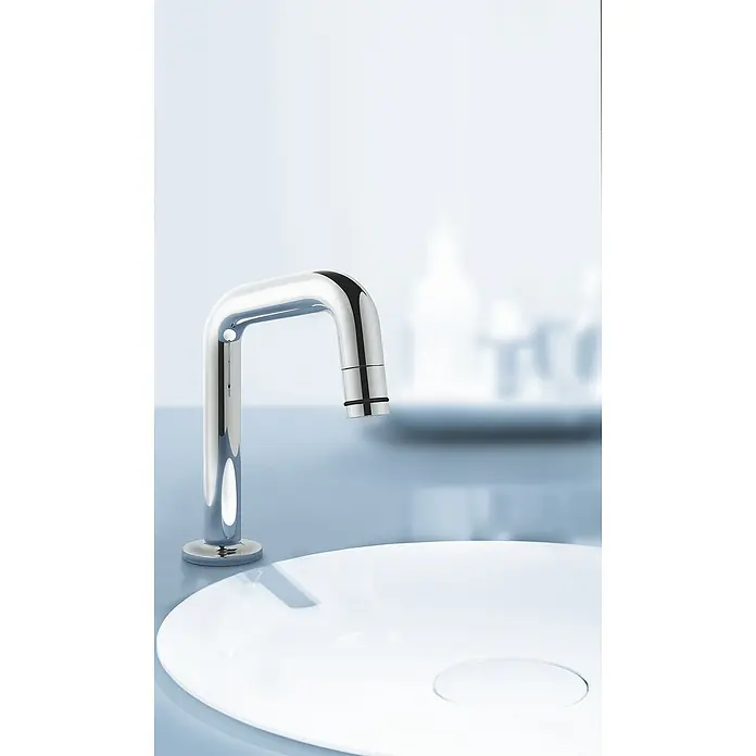 Grohe Kaltwasser-Standventil Universal - U-Auslauf, Chrom, Glänzend - Ein moderner, verchromter Wasserhahn über einem stilvollen, runden Waschbecken, perfekt für ein minimalistisches Badezimmerdesign.