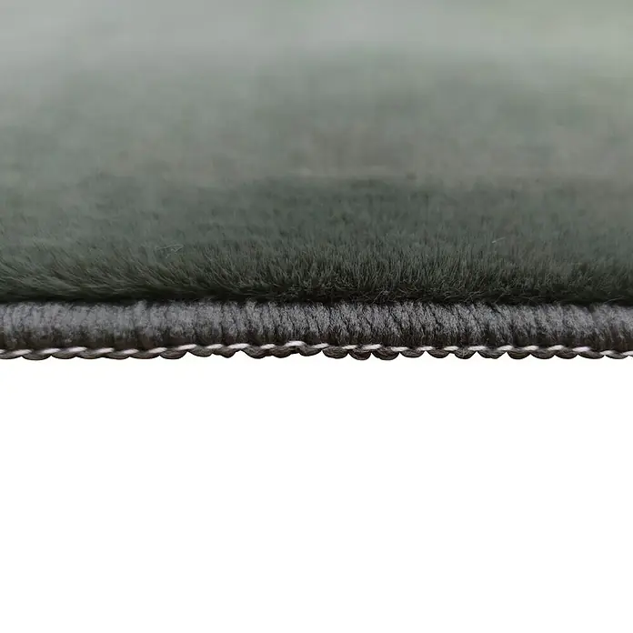 Alfombra de pelo corto Aiden - Kaki, 170 x 120 cm, Poliéster - Detalle de una alfombra gris que muestra su fina textura y detalles de borde blanco, destacando la calidad artesanal.