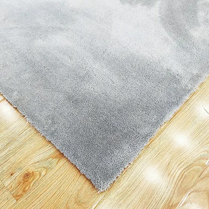 Alfombra de pelo corto Toscana - Plateado, 300 x 200 cm, 100% Poliéster - Primer plano de una alfombra suave y gris sobre un suelo de madera clara, creando un ambiente acogedor y elegante.