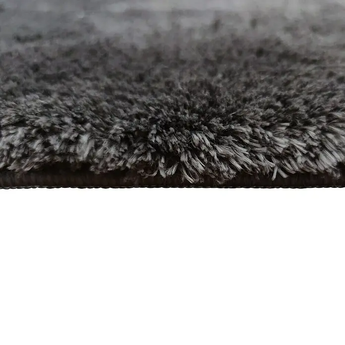 Alfombra de pelo largo Bolonia - Café, 115 x 60 cm, 100% Poliéster - Primer plano de una alfombra gris con fibras suaves, perfecta como revestimiento de suelo para un hogar acogedor.