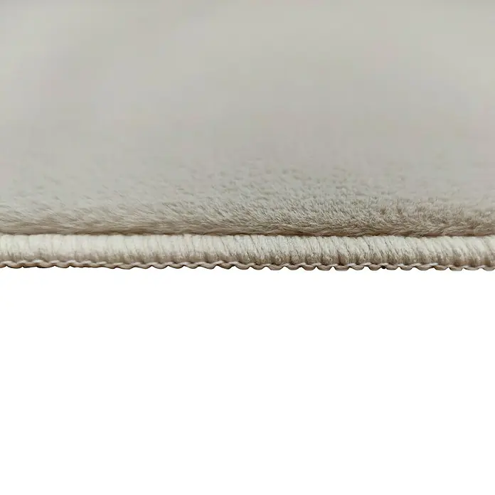 Alfombra de pelo corto Aiden - Arena, 170 x 120 cm, Poliéster - Primer plano del borde suave y blanco de una alfombra con un borde cosido y limpio.