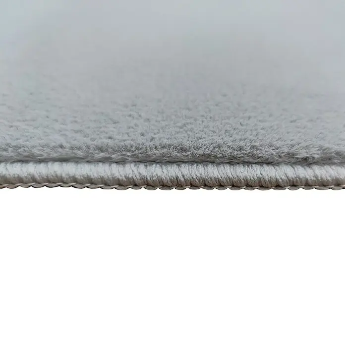 Alfombra de pelo corto Aiden - Gris, 170 x 120 cm, Poliéster - Primer plano de la textura suave y el borde de una alfombra gris, mostrando su confort y calidad.