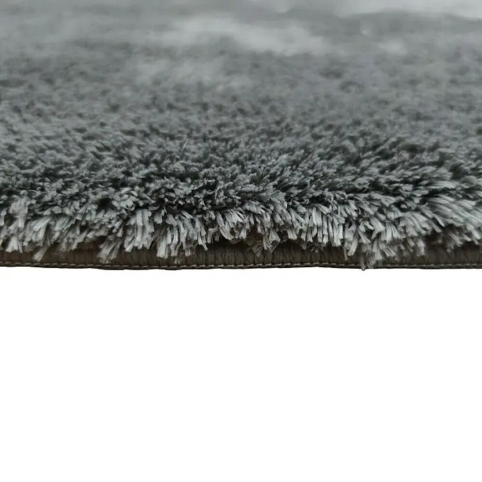 Alfombra de pelo largo Bolonia - Plata, 115 x 60 cm, 100% Poliéster - Primer plano de una alfombra gris con fibras largas y suaves, destacando su textura afelpada y construcción densa.