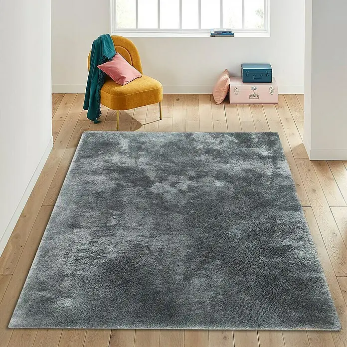 Alfombra de pelo largo Bolonia - Plata, 115 x 60 cm, 100% Poliéster - Una alfombra rectangular gris se encuentra en una habitación con pisos de madera, dando un toque de confort.