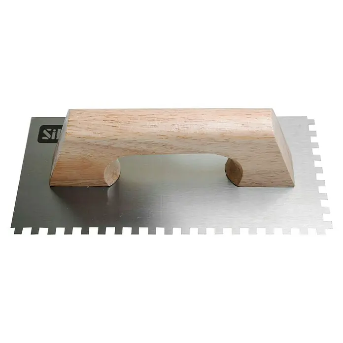 Llana dentada - 130 x 270 mm - Primer plano de una llana dentada de acero inoxidable con mango de madera, una herramienta para trabajos de alicatado.