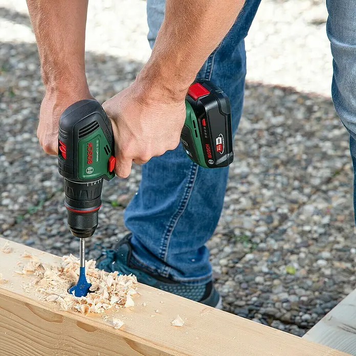 Bosch Power for All 18V Akku-Bohrschrauber AdvancedDrill 18V-80 QuickSnap - 18 V, Ohne Akku, 78 Nm, 3 Aufsätze - Der Akku-Bohrschrauber AdvancedDrill 18V-50 von Bosch im Einsatz. Ein Mann bohrt ein Loch in ein Holzbrett.