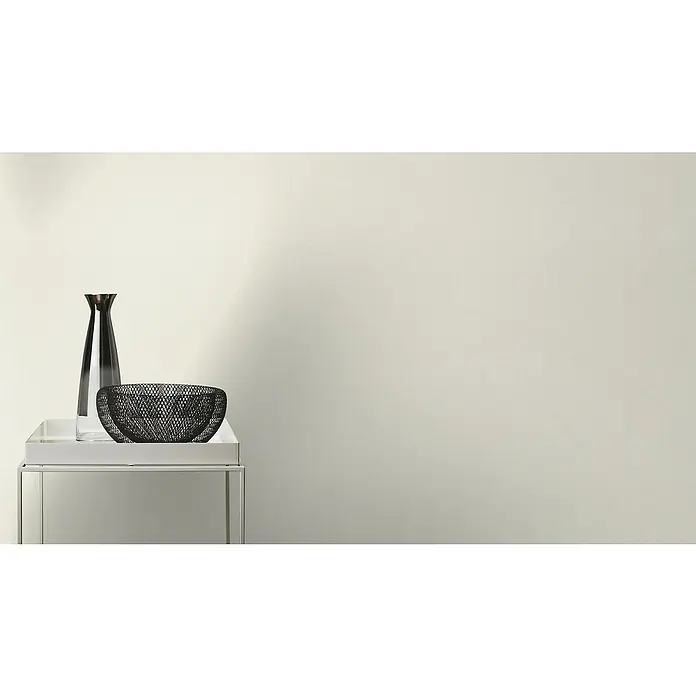 Rasch Tapetenwechsel Vliestapete Classic Style - Creme, Uni, 10,05 x 0,53 m - Elegante Tischdekoration mit einer schlanken Glasvase und einer dekorativen Metallschale auf einem modernen Beistelltisch.
