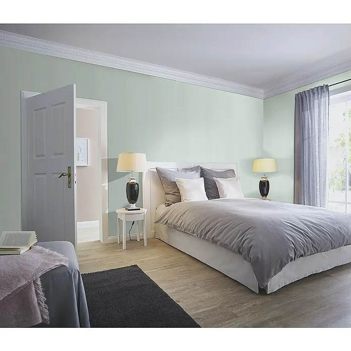 Rasch Tropical House Vliestapete - Hellblau, Uni, 10,05 x 0,53 m - Schlafzimmer mit einem grauen Bettbezug, Nachttischlampe und einem offenen Türrahmen.