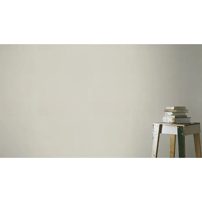 Rasch Tapetenwechsel Vliestapete Classic Style - Taupe, Uni, 10,05 x 0,53 m - Bücherstapel auf einem kleinen Holzhocker vor einer schlichten Wand. Dekorative und ruhige Szene mit Fokus auf Literatur.
