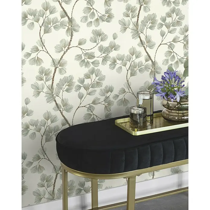 Rasch Symphony Vliestapete Blätter - Moosgrün, Floral, 10,05 x 0,53 m - Elegante, schwarze Sitzbank mit goldenem Gestell und dekorativen Elementen auf einem goldenen Tablett.