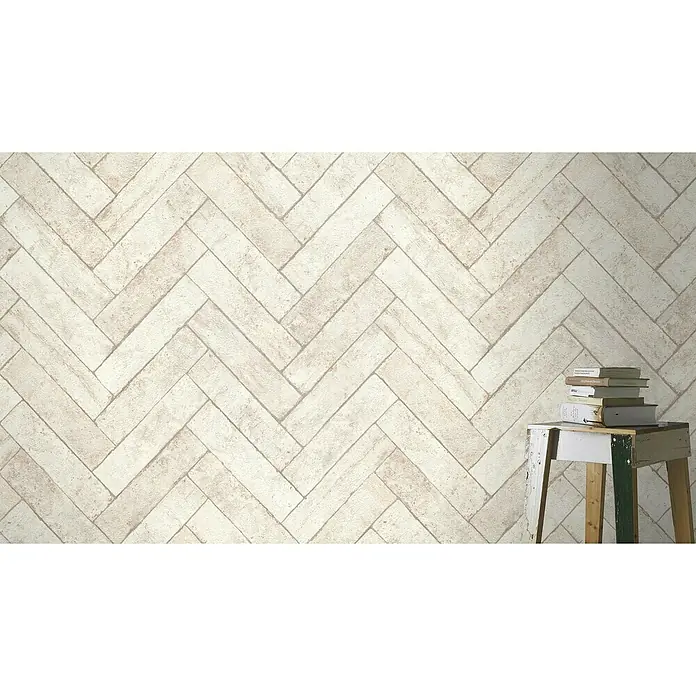 Rasch Factory V Vliestapete Bricks - Kalkstein, Steinoptik, 10,05 x 0,53 m - Nahaufnahme von stilvollen hellen Ziegeln im Fischgrätmuster, die eine warme und einladende Atmosphäre schaffen.