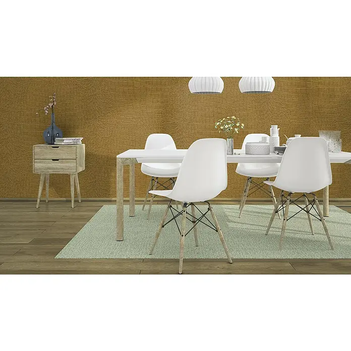 Rasch African Queen III Vliestapete Krokodilleder - Gold, Lederoptik, 10,05 x 0,53 m - Einrichtung mit weißen Eames-Stühlen und einem Esstisch, akzentuiert durch eine Nachttischlampe. Die goldene Wand verleiht Wärme.