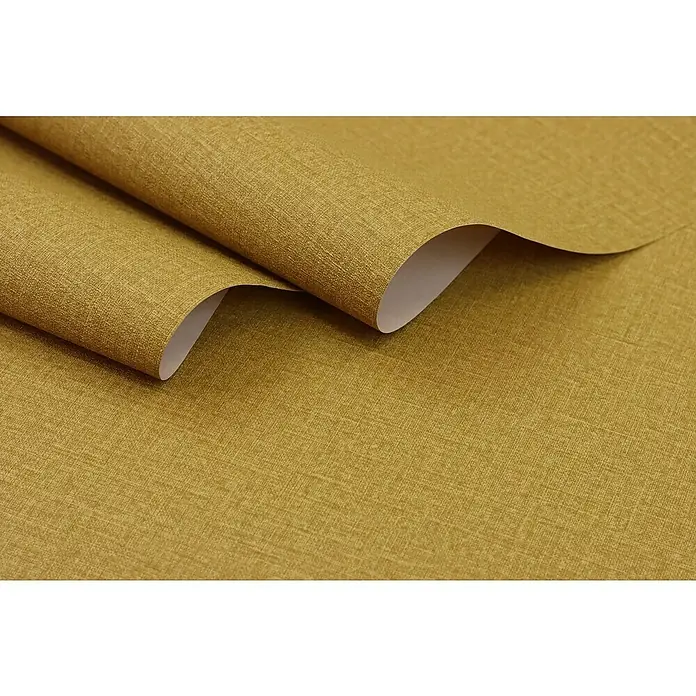 Rasch Wall Textures VI Vliestapete Leinen-Uni - Ocker, Uni, 10,05 x 0,53 m - Nahaufnahme einer Rolle goldfarbener Textiltapete mit feiner Leinenstruktur, die sich aufrollt und die weiße Rückseite zeigt.