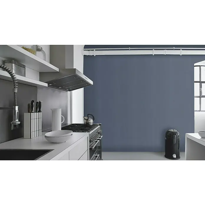 Rasch Color your life Vliestapete Struktur-Uni - Dunkelblau, Uni, 10,05 x 0,53 m - Eine moderne Küche mit Edelstahl-Dunstabzugshaube, Kochfeld, stilvollem Wasserkocher und einer Ablage mit Messern und Schüsseln.