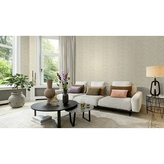 Rasch Sky Lounge Vliestapete Graphik - Champagner, Grafisch, 10,05 x 0,53 m - Ein helles Wohnzimmer mit einem modernen Sofa, einem runden Couchtisch und einer stilvollen Stehlampe. Die harmonische Einrichtung schafft eine gemütliche Atmosphäre.