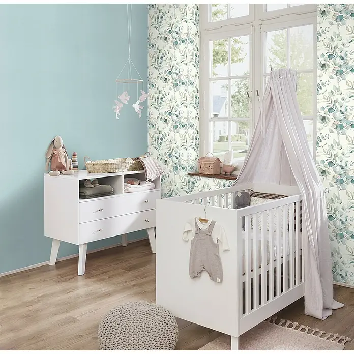 Rasch Kids World Vliestapete Textil-Uni - Hellblau, Uni, 10,05 x 0,53 m - Ein stilvolles Kinderzimmer mit weißem Kinderbett, Wickelkommode und floraler Tapete, das eine beruhigende Atmosphäre schafft.